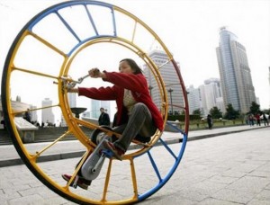 A woman rides an unicycle at a park in Shanghai February 28, 2004. The unicycle was designed several years ago by Chinese inventor Li Yongli who called it "the number one vehicle in the world". NO RIGHTS CLEARANCES OR PERMISSIONS ARE REQUIRED FOR THIS IMAGE REUTERS/China Photos ASW
